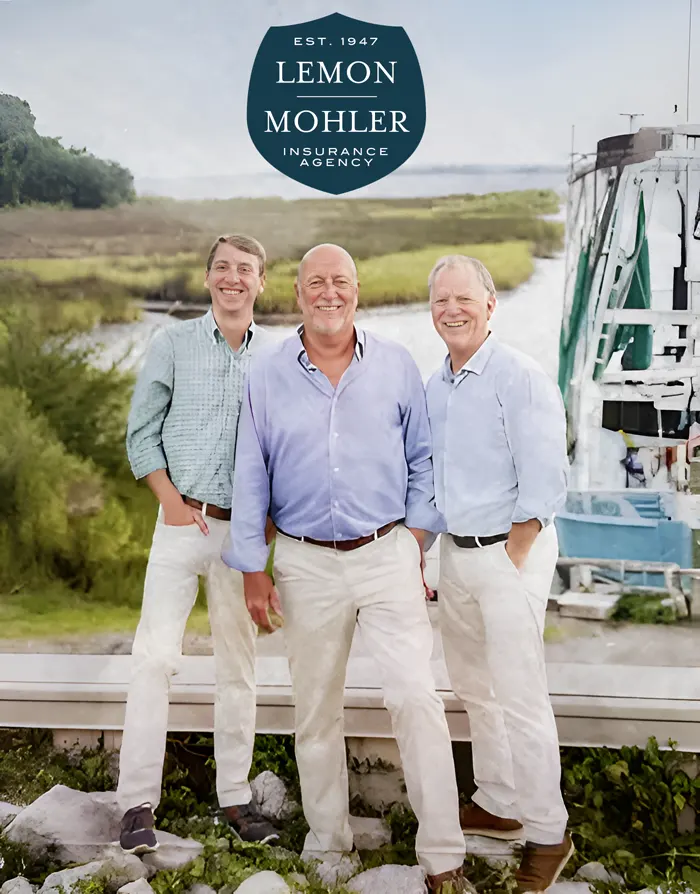 Lemon Mohler Leadership Team stands on waters edge near boat